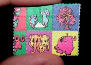 A person holding LSD blotter paper next to a UK-to-Netherlands shipping label, representing the safety of sending acid between countries